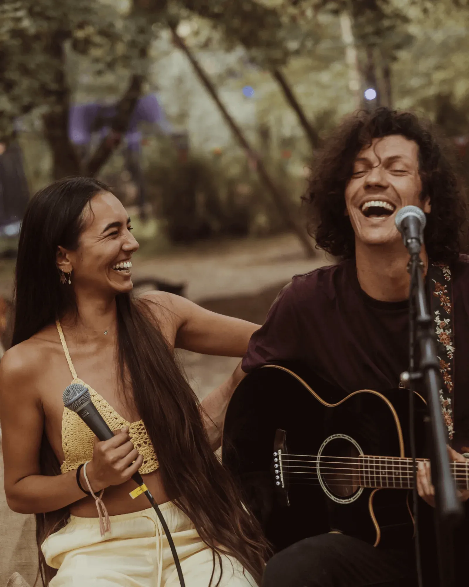 Dois músicos a cantar e a tocar guitarra ao entardecer