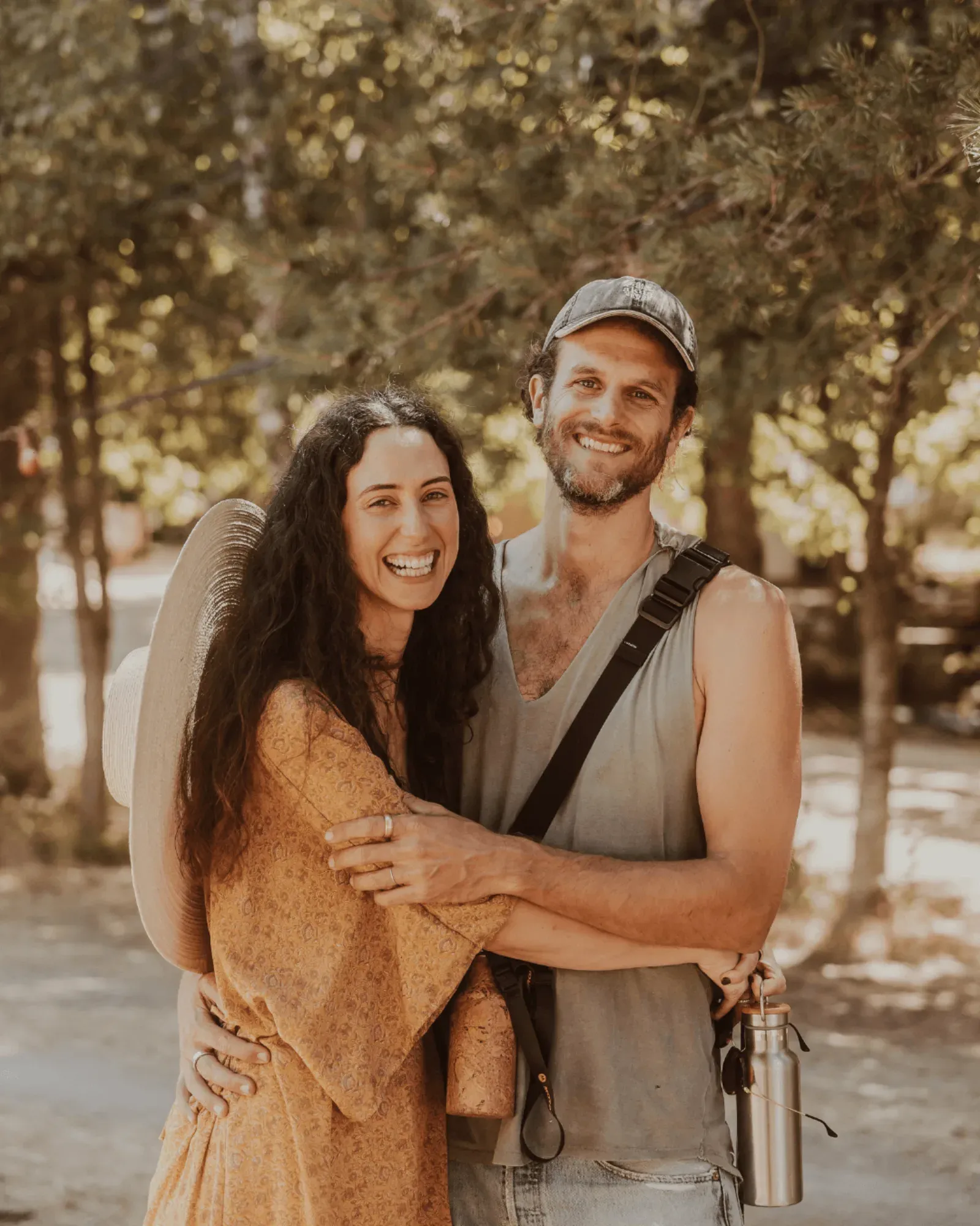 Um casal abraçado e a sorrir na floresta